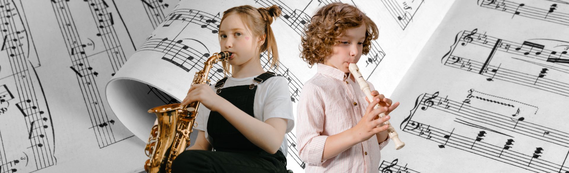 Man sieht ein Mädchen mit einem Saxophon und einen Jungen mit einer Blockflöte
